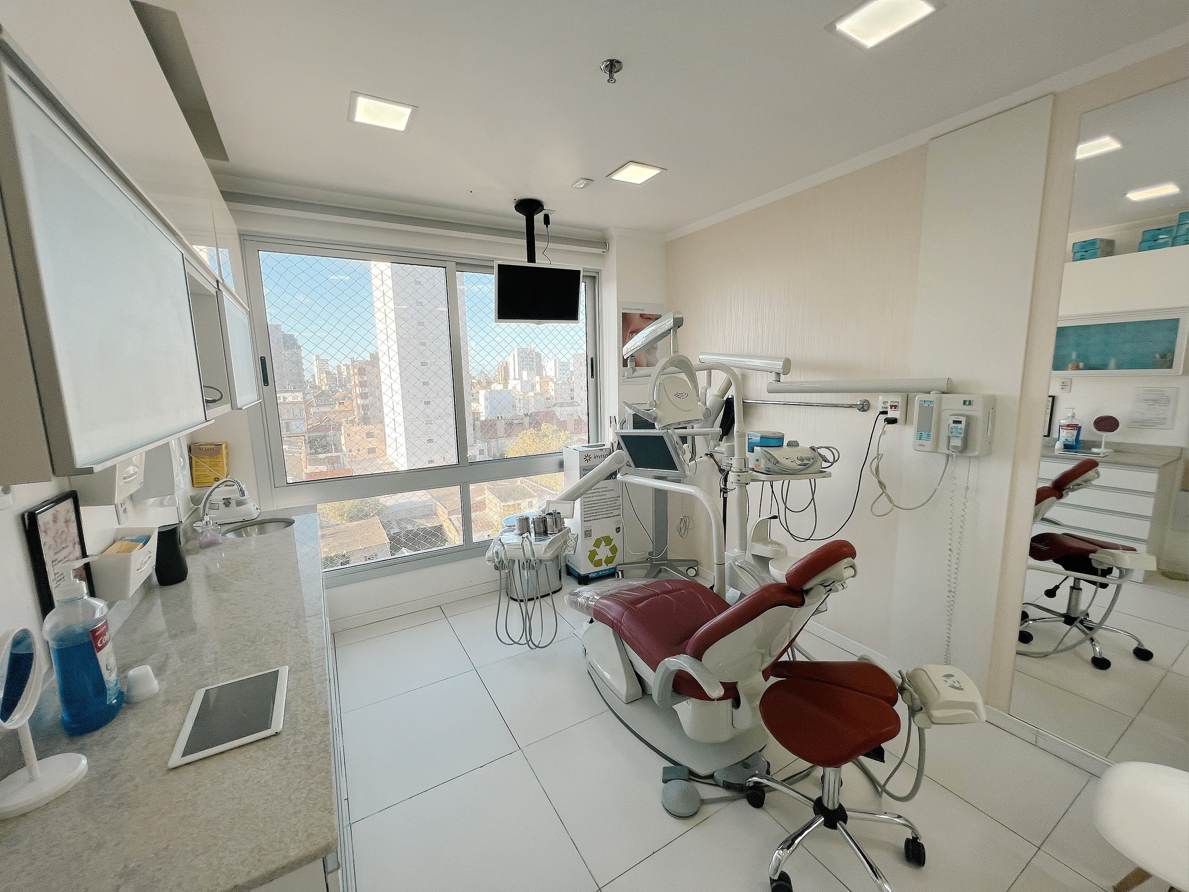 Consultório com cadeira odontológica e vista para a cidade